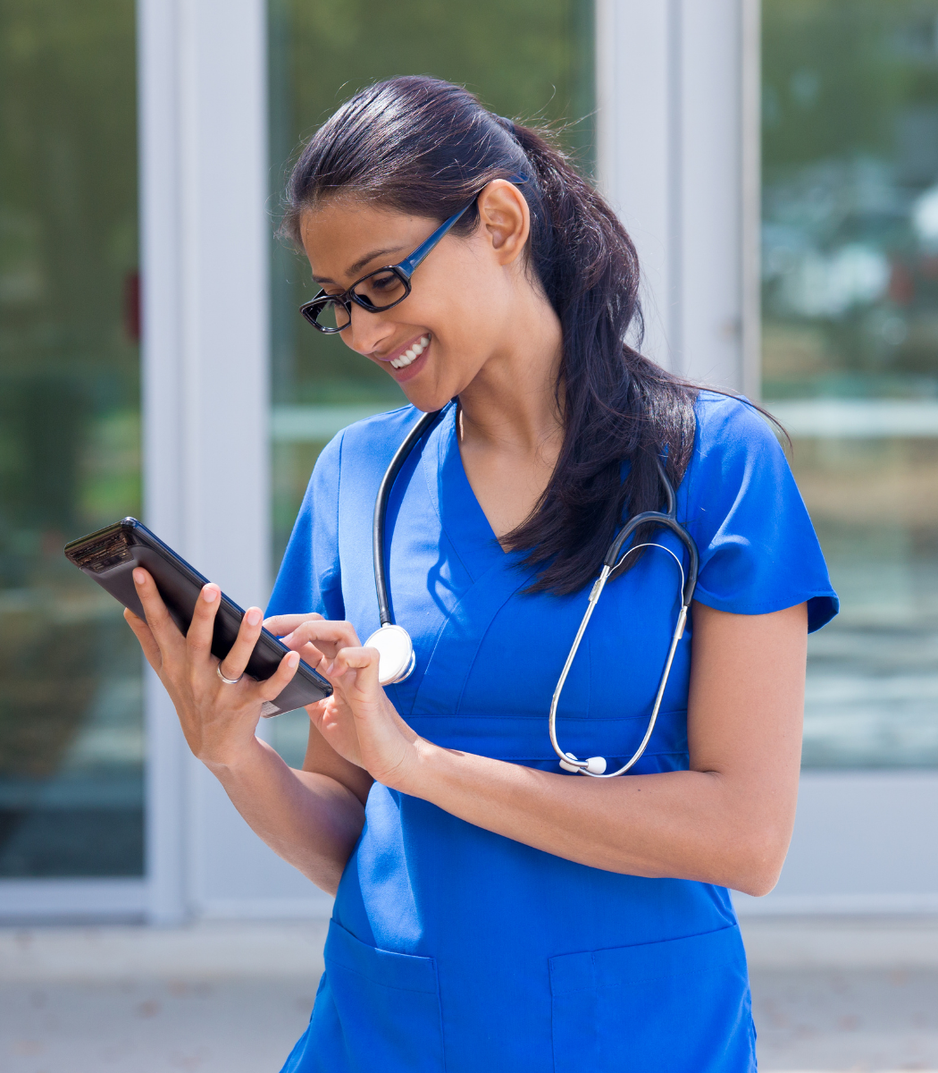 Nurse in UAE using hospital management software on a tablet to manage patient care and hospital tasks 
